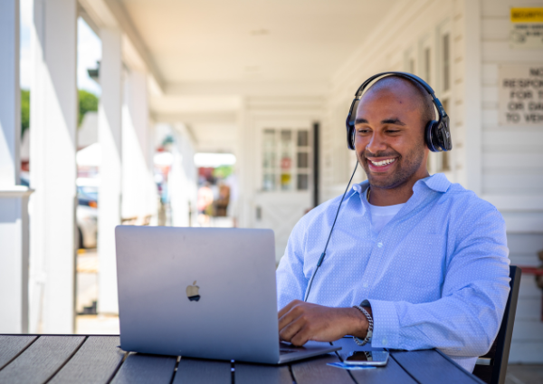 Smiling man with headphones using laptop
